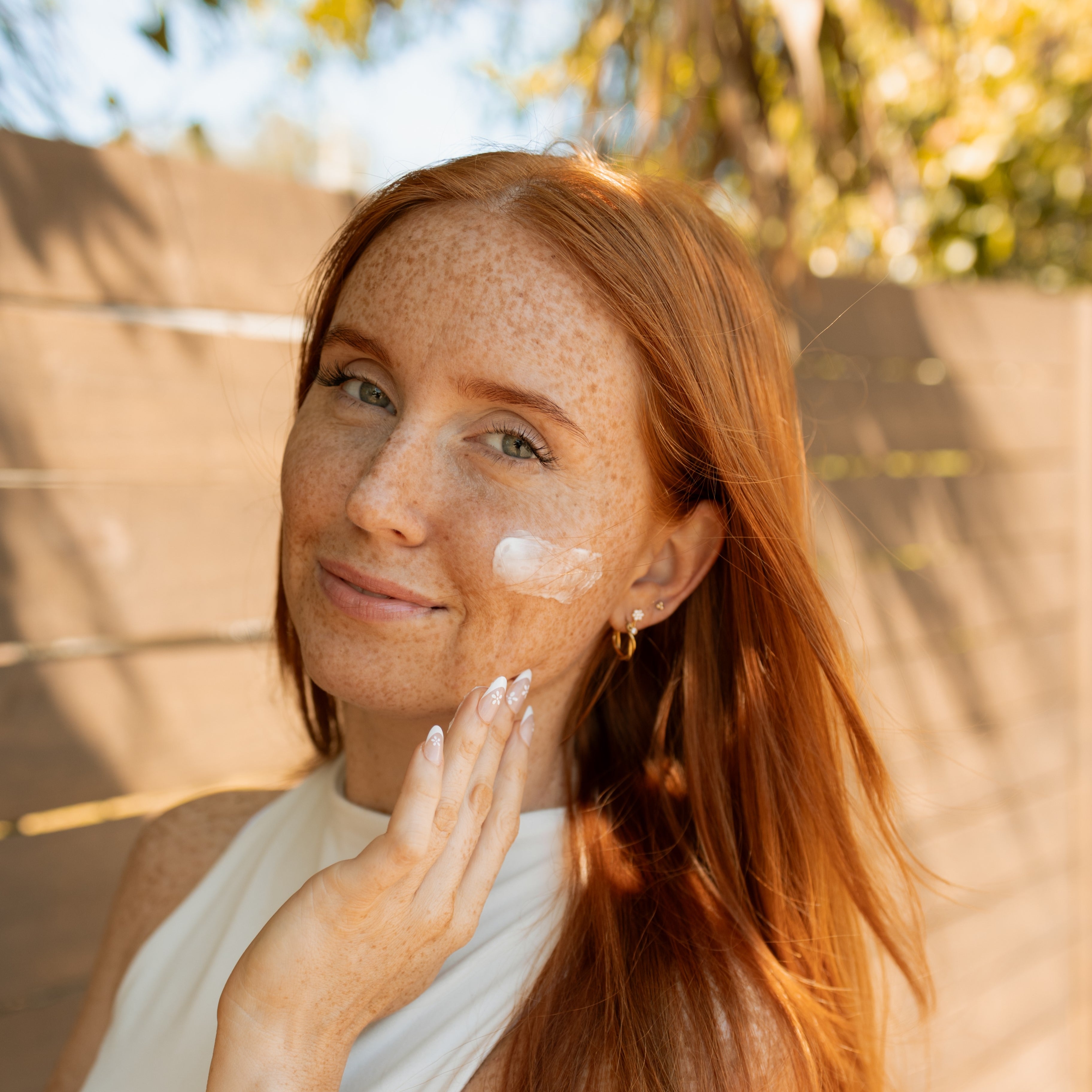 Woman with glowing skin applying tallow balm to her face, highlighting the nourishing benefits of natural skincare for every skin type (dry skin, combination skin, normal skin, sensitive skin, oily skin).
