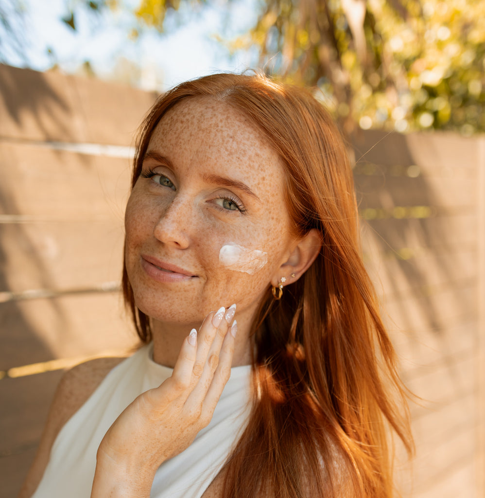 Woman with glowing skin applying tallow balm to her face, highlighting the nourishing benefits of natural skincare for every skin type (dry skin, combination skin, normal skin, sensitive skin, oily skin).