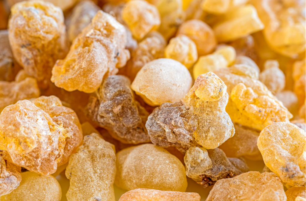 Close-up of golden frankincense resin pieces, highlighting their textured surface and amber color, representing a natural remedy for soothing psoriasis.