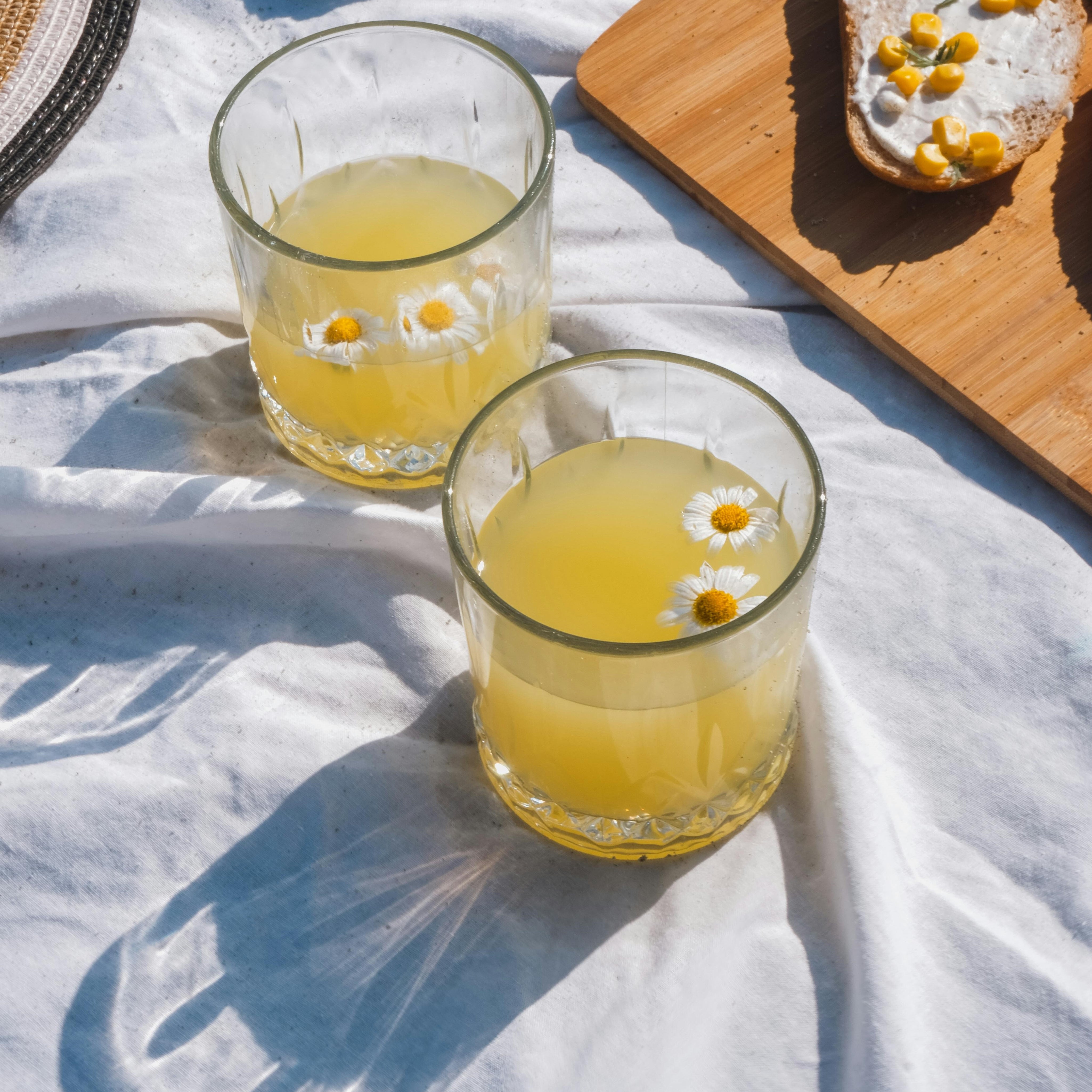 A refreshing drink adorned with colorful flowers, symbolizing the gentle and nourishing properties of herbal-infused oils in skincare.