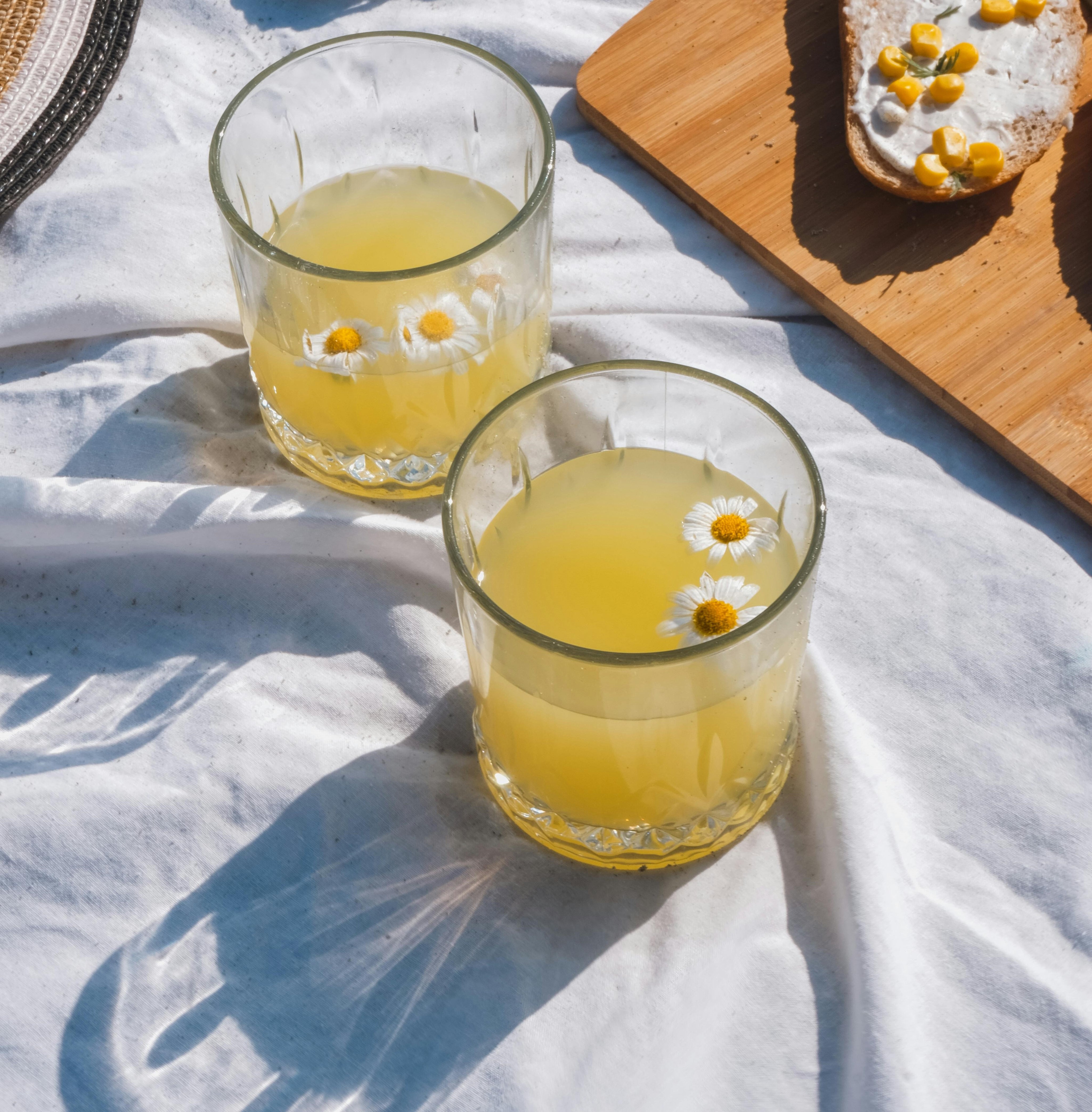 A refreshing drink adorned with colorful flowers, symbolizing the gentle and nourishing properties of herbal-infused oils in skincare.