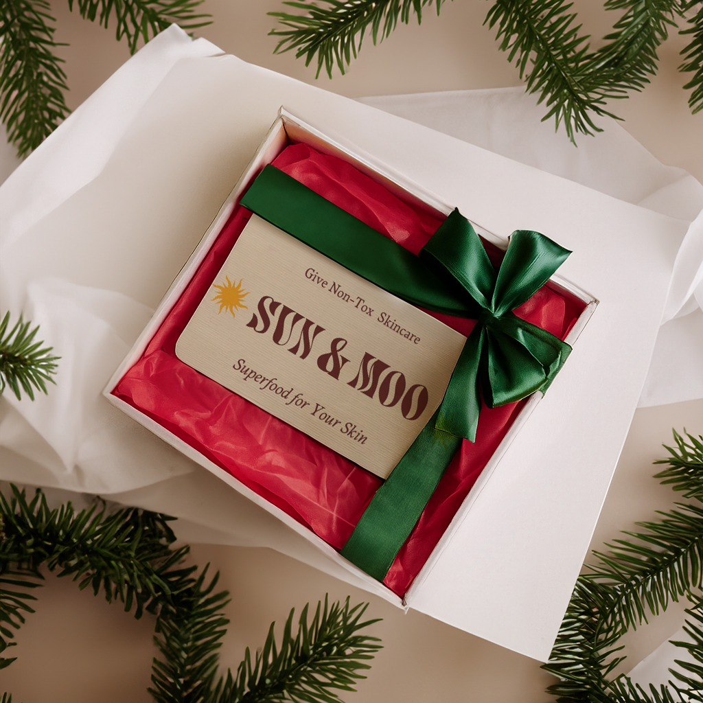 Gift_box_with_red_interior_green_bow_and_visible_brand_name_surrounded_by_pine_branches..png